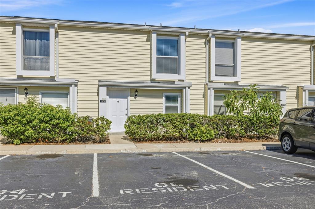 A two-story townhouse with light yellow siding and a parking lot in front — 11906 CYPRESS HILL CIRCLE, TAMPA, FL