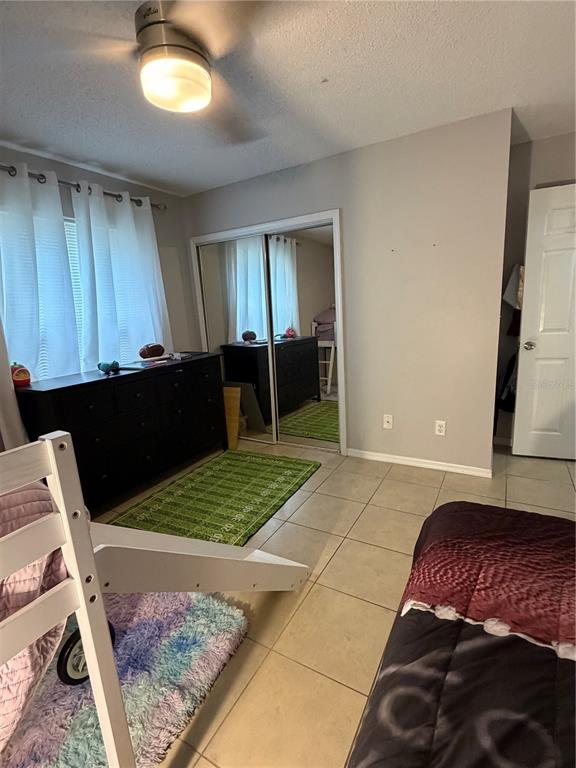 A bedroom features tile flooring, a dark dresser, mirrored closet doors, and a bunk bed — 615 RICHLAND COURT UNIT 69, ALTAMONTE SPRINGS, FL