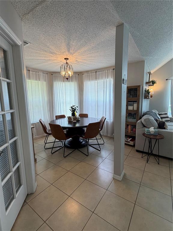 A dining area with a round table and chairs sits beside a living room — 615 RICHLAND COURT UNIT 69, ALTAMONTE SPRINGS, FL