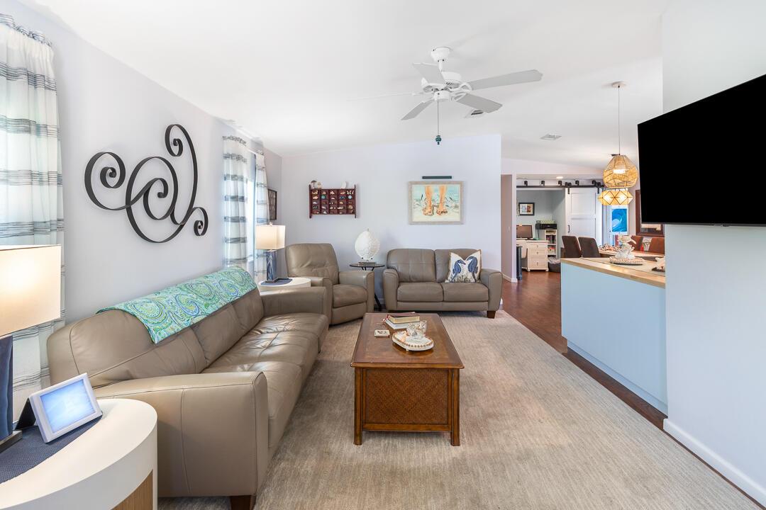 A living room features a leather sofa, a coffee table, and a wall-mounted television — 400 N Highway A1a # 88, Jupiter FL 33477, JUPITER, FL