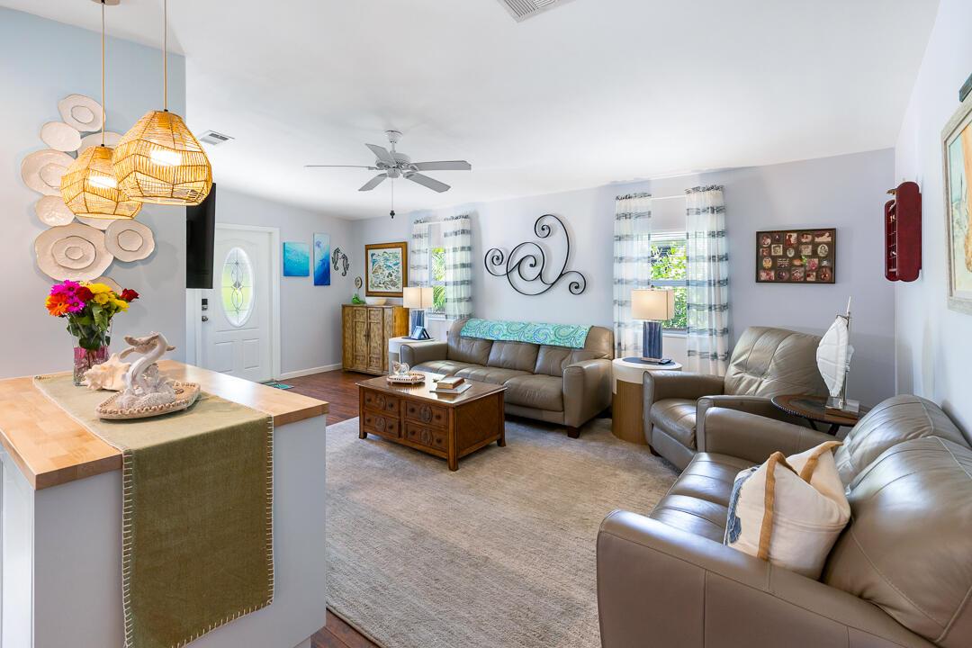 A living room with leather furniture, a wooden coffee table, and a kitchen island — 400 N Highway A1a # 88, Jupiter FL 33477, JUPITER, FL