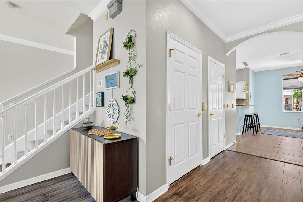 An entryway features a staircase, a wooden console table, and two white doors — 1014 34TH DRIVE W, PALMETTO, FL