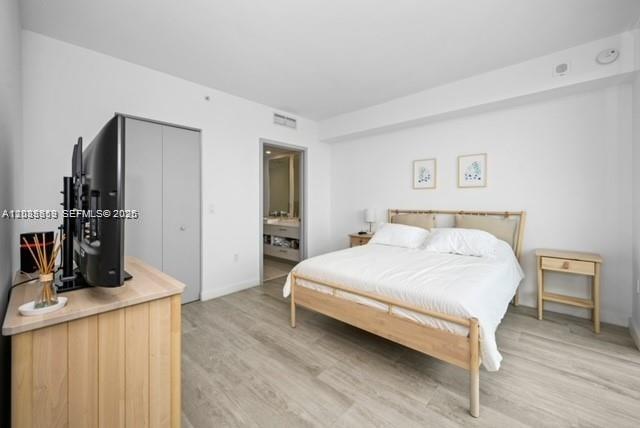 A bedroom features a light wood bed frame, matching nightstands, and a television on a dresser — 55 SW 9th St # 3506, Miami FL 33130, MIAMI, FL