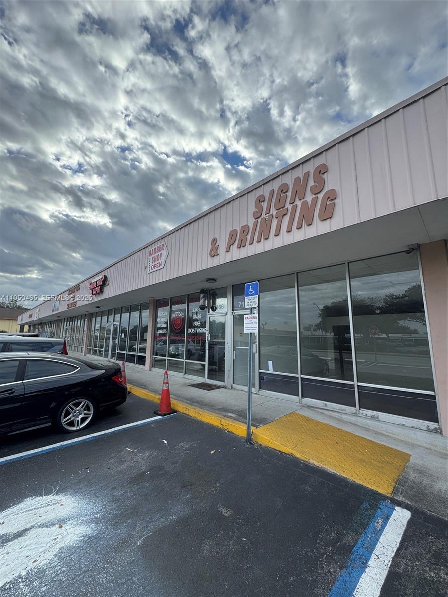 A commercial strip mall storefront features a large sign reading Signs & Printing — 7150 Pembroke Rd # 7168, Miramar FL 33023, MIRAMAR, FL
