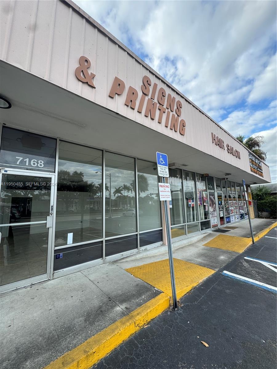 The exterior of a commercial strip mall building features storefront windows and signage — 7150 Pembroke Rd # 7168, Miramar FL 33023, MIRAMAR, FL