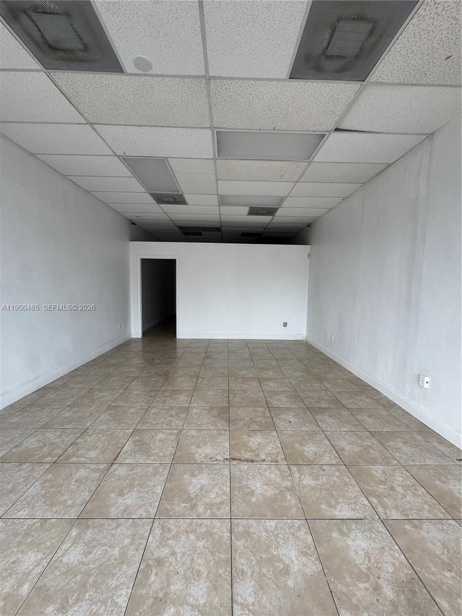 An empty commercial space features white walls, tan tiled floors, and a drop ceiling — 7150 Pembroke Rd # 7168, Miramar FL 33023, MIRAMAR, FL