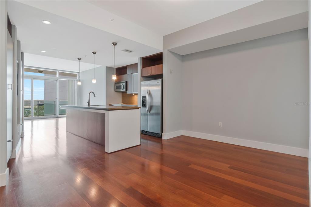 A modern kitchen features a central island, stainless steel appliances, and hardwood flooring — 111 N 12TH STREET UNIT 1608, TAMPA, FL