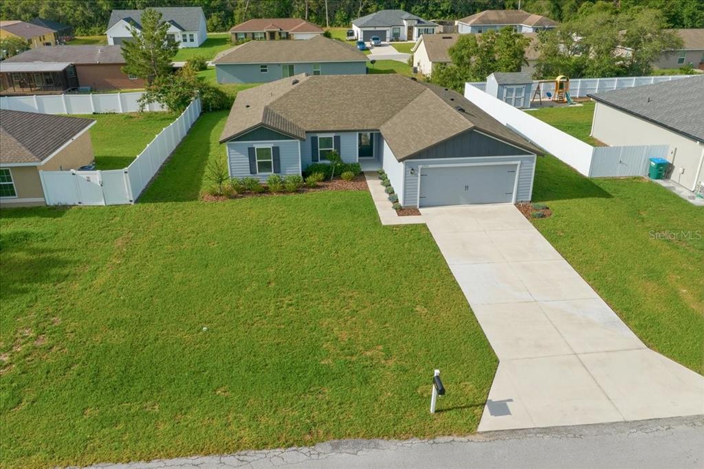 An aerial view shows a light blue single-story house with a two-car garage and lawn — 2722 SW 151 PLACE, OCALA, FL