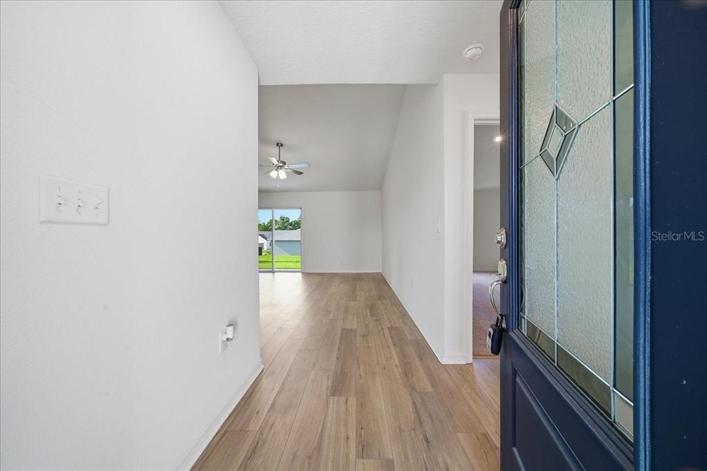 An entryway leads into a living area with light wood-look flooring and a ceiling fan — 2722 SW 151 PLACE, OCALA, FL