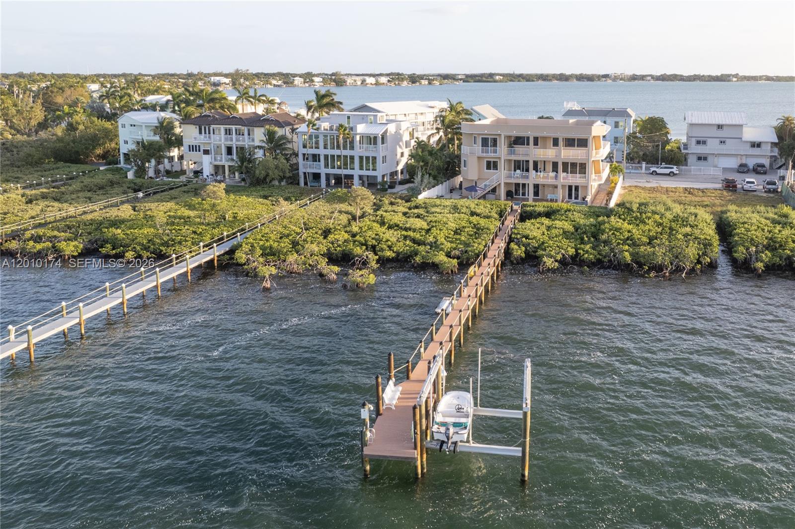 An aerial view shows waterfront homes with long wooden docks extending into the bay — 112 N Bounty Ln, Key Largo FL 33037, KEY LARGO, FL