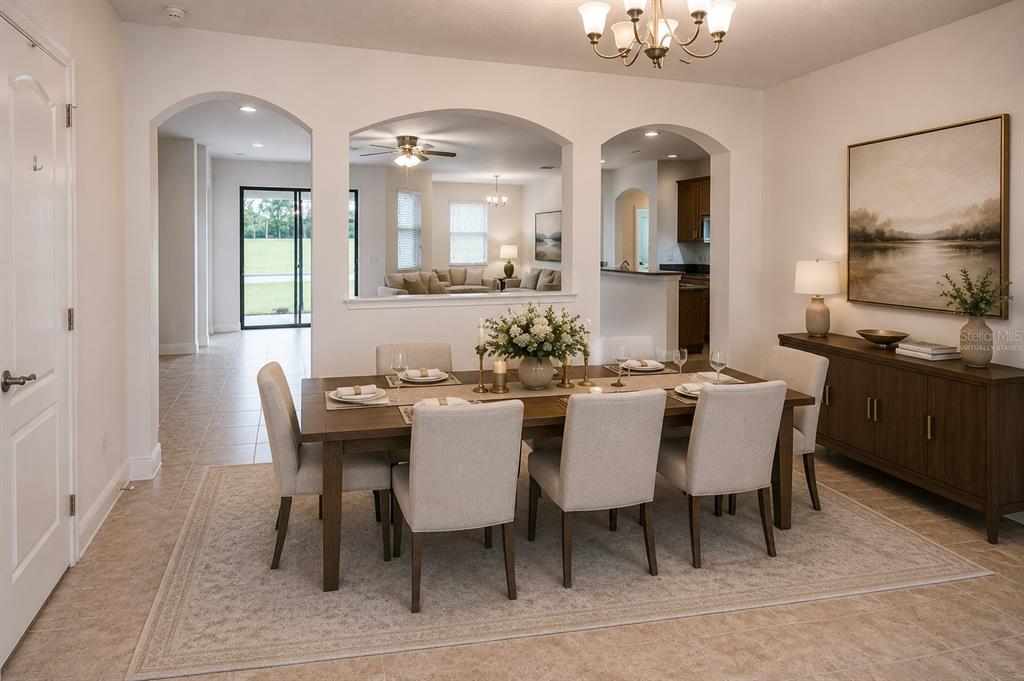 A dining room with a wooden table, six chairs, and arched openings to other rooms — 11619 IRIS SPRING COURT, RIVERVIEW, FL