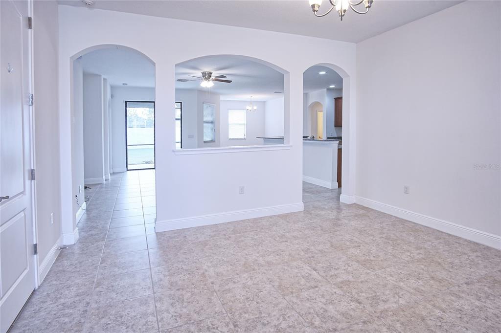 An interior view shows a tiled room with arched openings leading to other living spaces — 11619 IRIS SPRING COURT, RIVERVIEW, FL