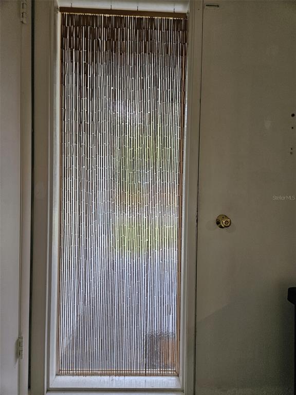 A doorway features a hanging bamboo bead curtain inside a white door frame — 2245 CEDAR DRIVE, DUNEDIN, FL