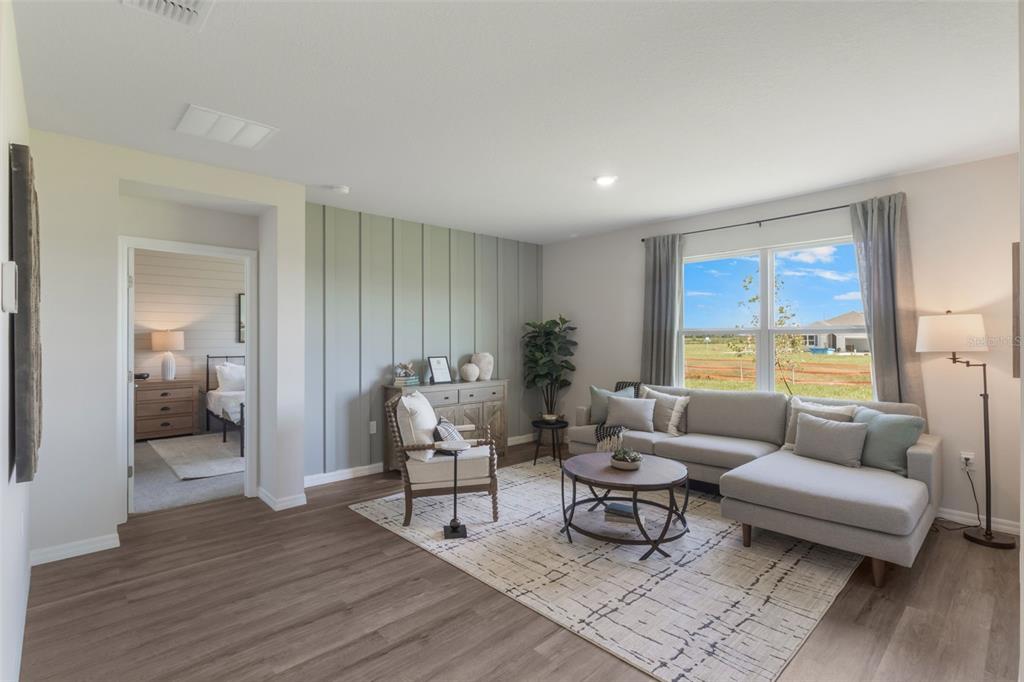 A living room features a light gray sectional sofa, board-and-batten accent wall, and wood flooring — 1779 GRANDIOSE DRIVE, HAINES CITY, FL