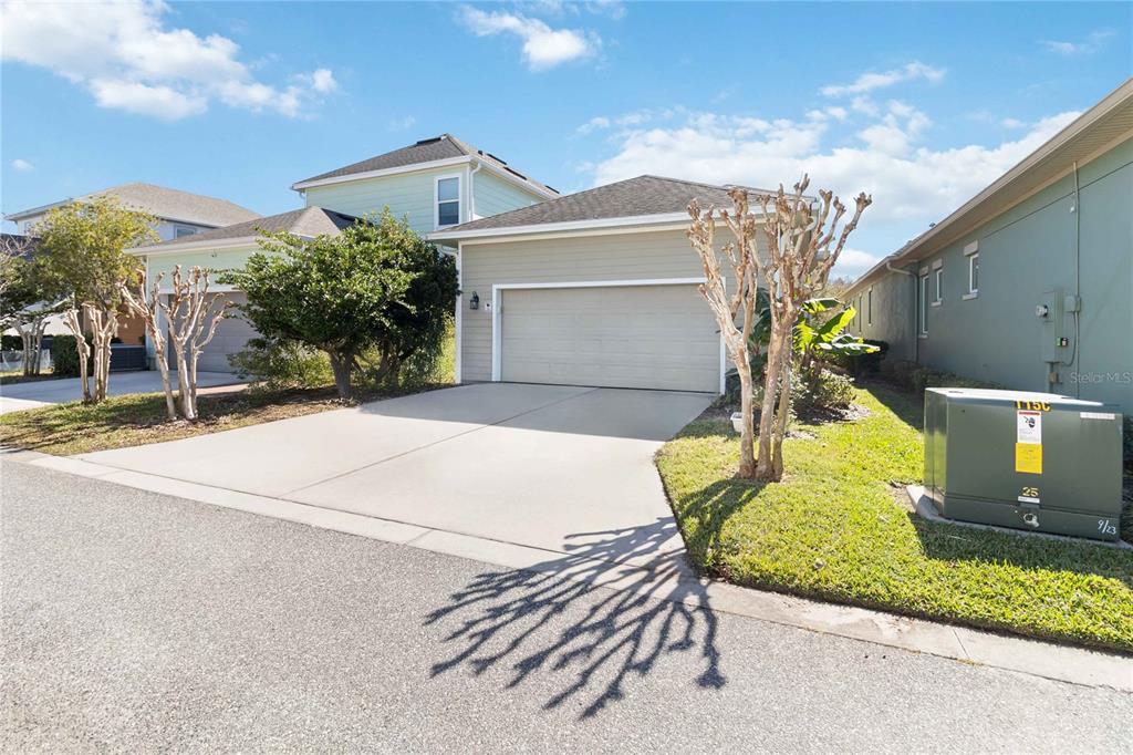 A tan single-story house with a two-car garage and a concrete driveway — 8905 LAUREATE BOULEVARD, ORLANDO, FL