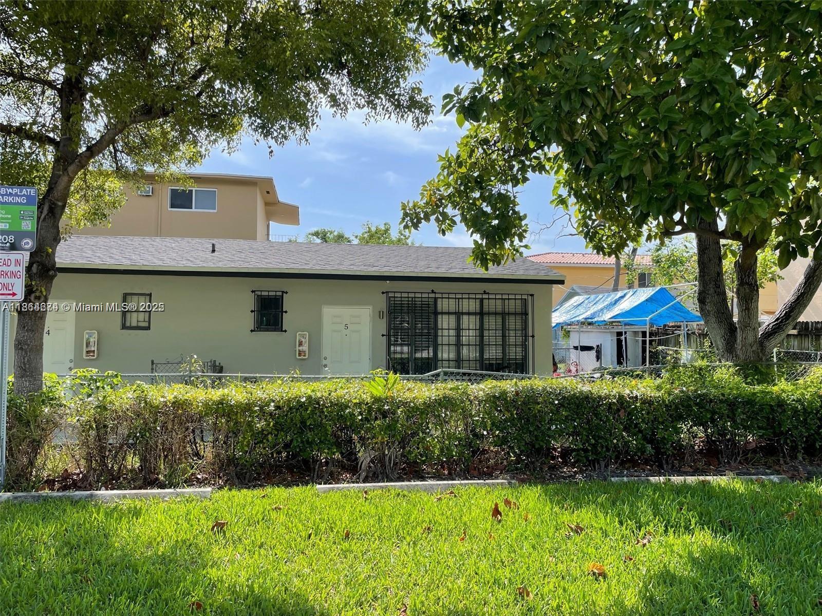 A single-story light green house with a white door and black window security bars — 1346 NW 6th St, Miami FL 33125, MIAMI, FL