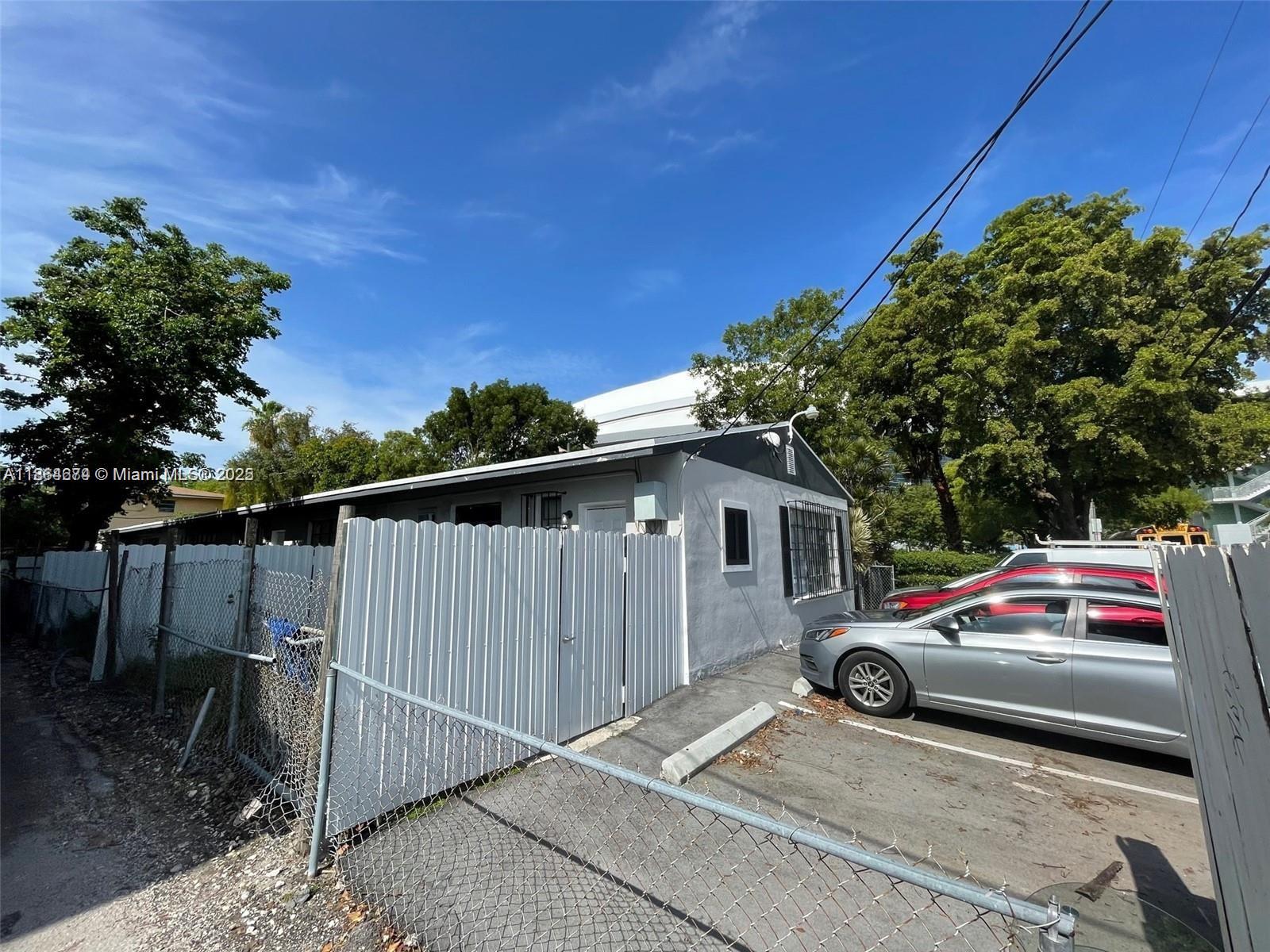 A gray house with a white fence and a parking area with two cars — 1346 NW 6th St, Miami FL 33125, MIAMI, FL