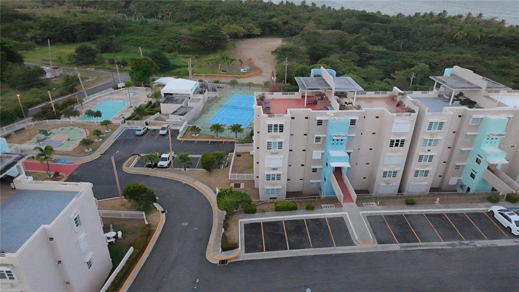 An aerial view of a multi-story apartment complex with a swimming pool and tennis court — Cond. VILLAS DEL FARO UNIT 3-301, MAUNABO, PR