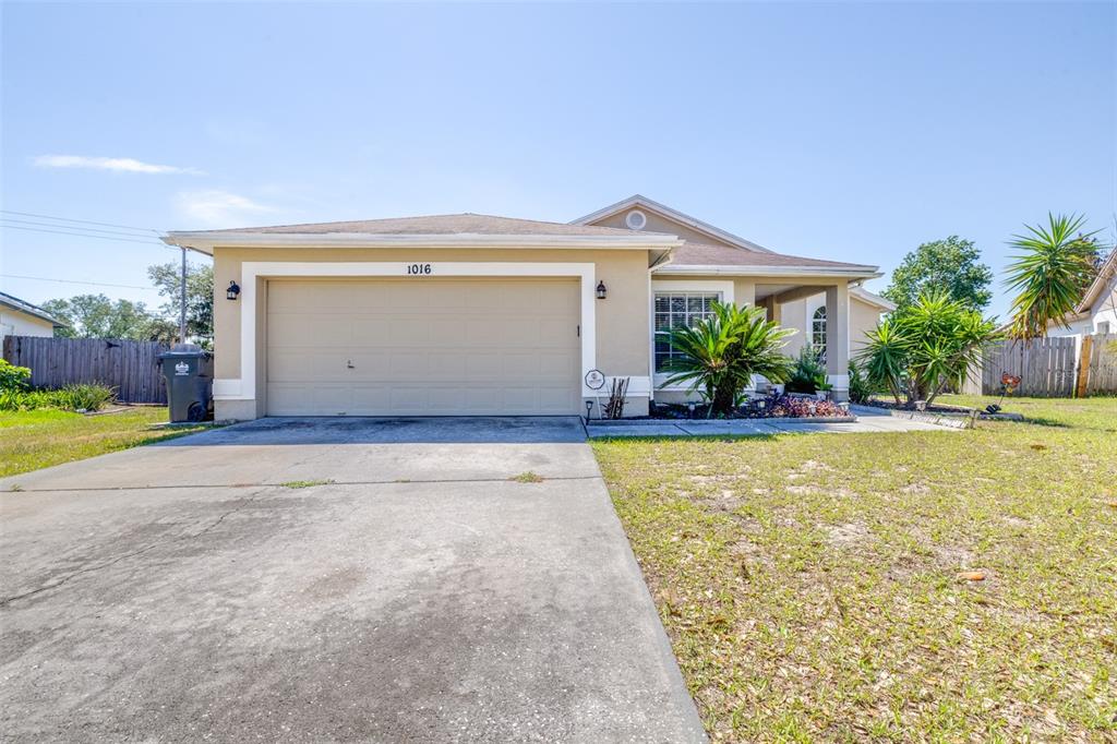 A single-story house with a beige exterior, a two-car garage, and a concrete driveway — 1016 MALLETWOOD DRIVE, BRANDON, FL