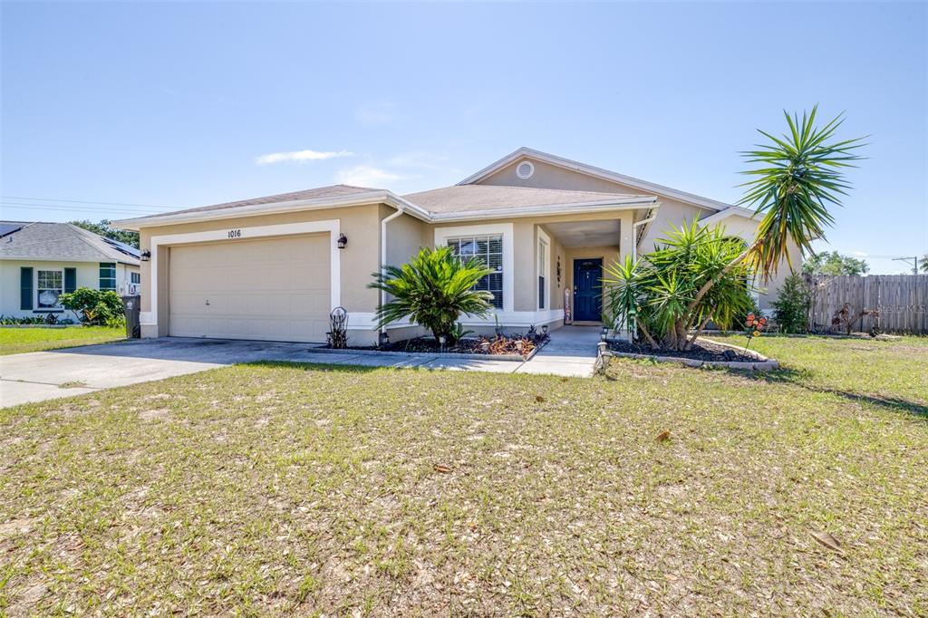 A single-story house with a beige stucco exterior, a two-car garage, and front landscaping — 1016 MALLETWOOD DRIVE, BRANDON, FL
