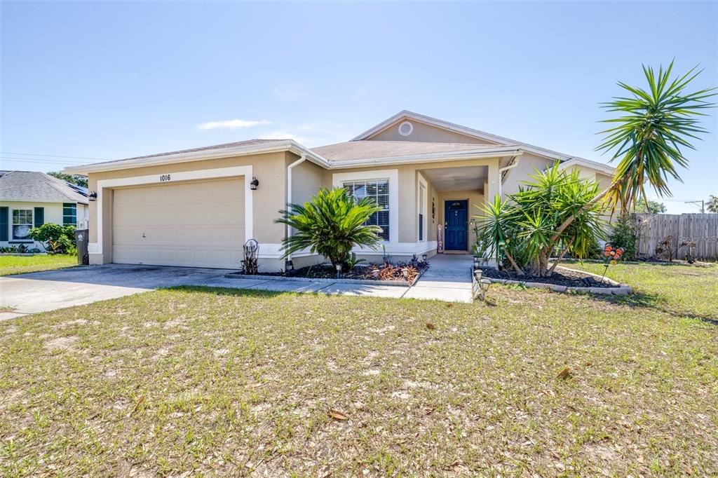 A single-story house with a beige stucco exterior, a two-car garage, and a front yard — 1016 MALLETWOOD DRIVE, BRANDON, FL