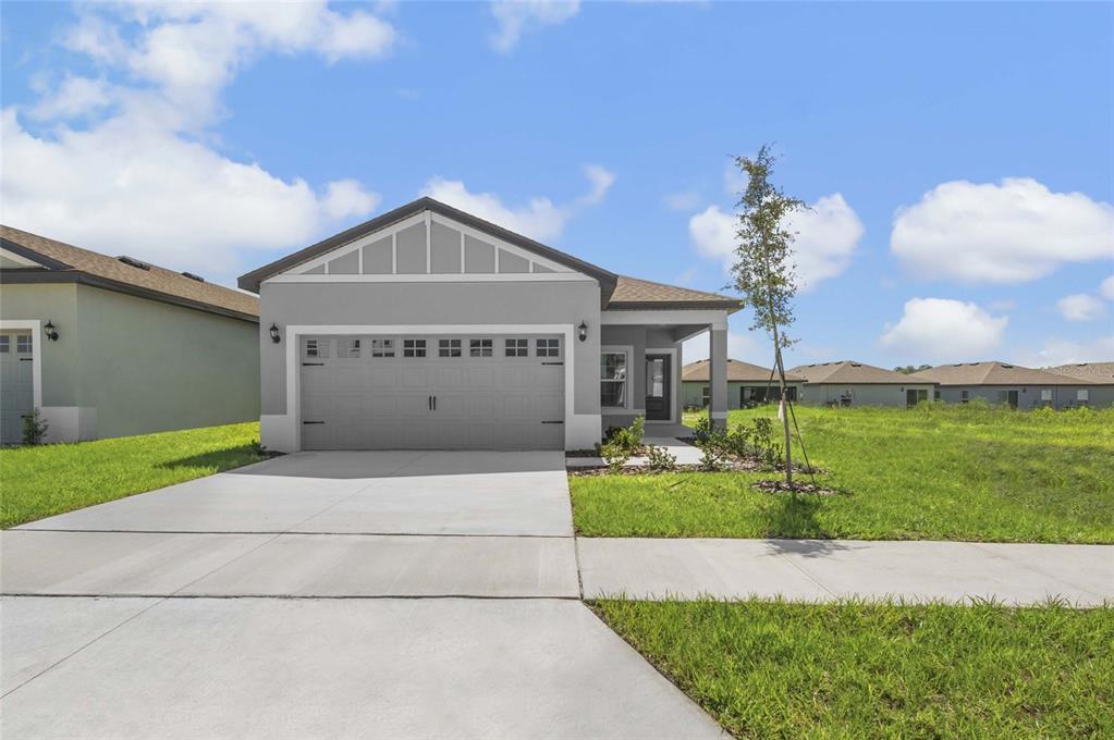 A single-story house with a gray exterior, a two-car garage, and a concrete driveway — 3621 AMANATSU AVENUE, LAKE ALFRED, FL