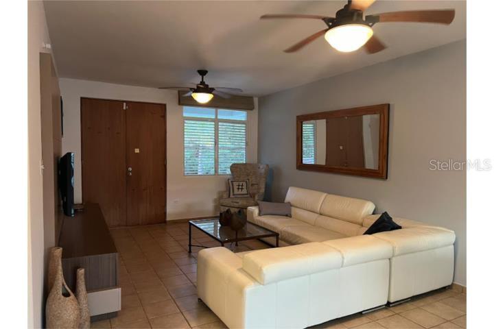 A living room features a white sectional sofa, a glass coffee table, and ceiling fans — 180 HARBOUR DRIVE UNIT 62D, HUMACAO, PR