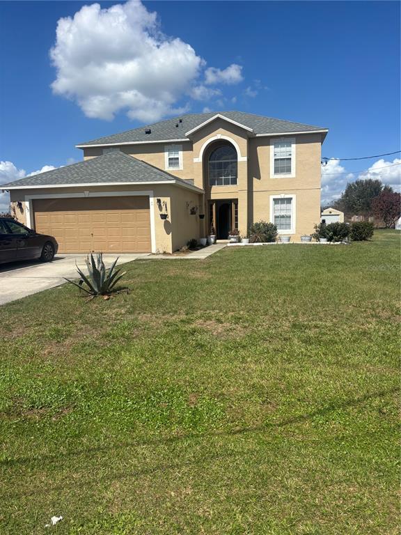 A two-story tan house with a two-car garage and a large front lawn — 335 COLUMBO STREET, WINTER HAVEN, FL