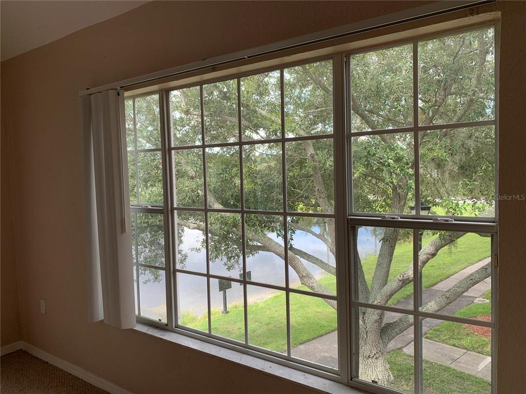 A kitchen with a breakfast bar and vaulted ceilings overlooks a living area with sliding doors — 9832 LAKE CHASE ISLAND WAY, TAMPA, FL