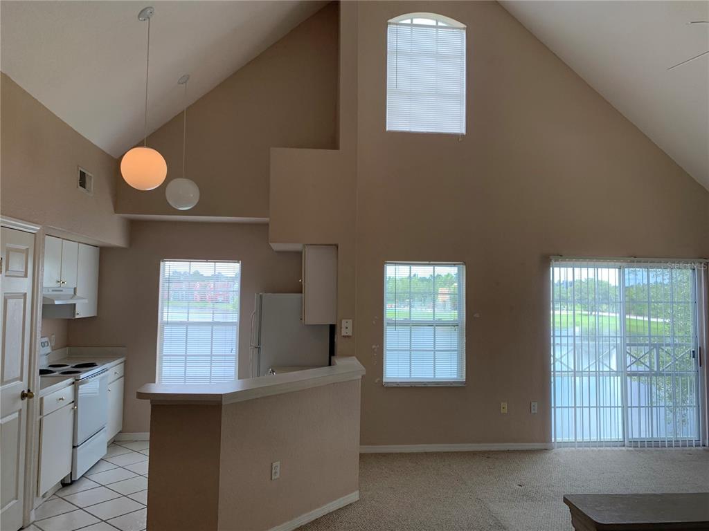 A kitchen with white cabinets, light wood-look flooring, and a breakfast bar — 9832 LAKE CHASE ISLAND WAY, TAMPA, FL