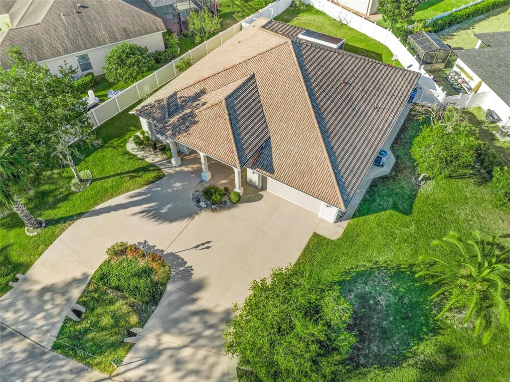 An aerial view shows a house with a tiled roof, a driveway, and a fenced yard — 3 FALLS PLACE, PALM COAST, FL