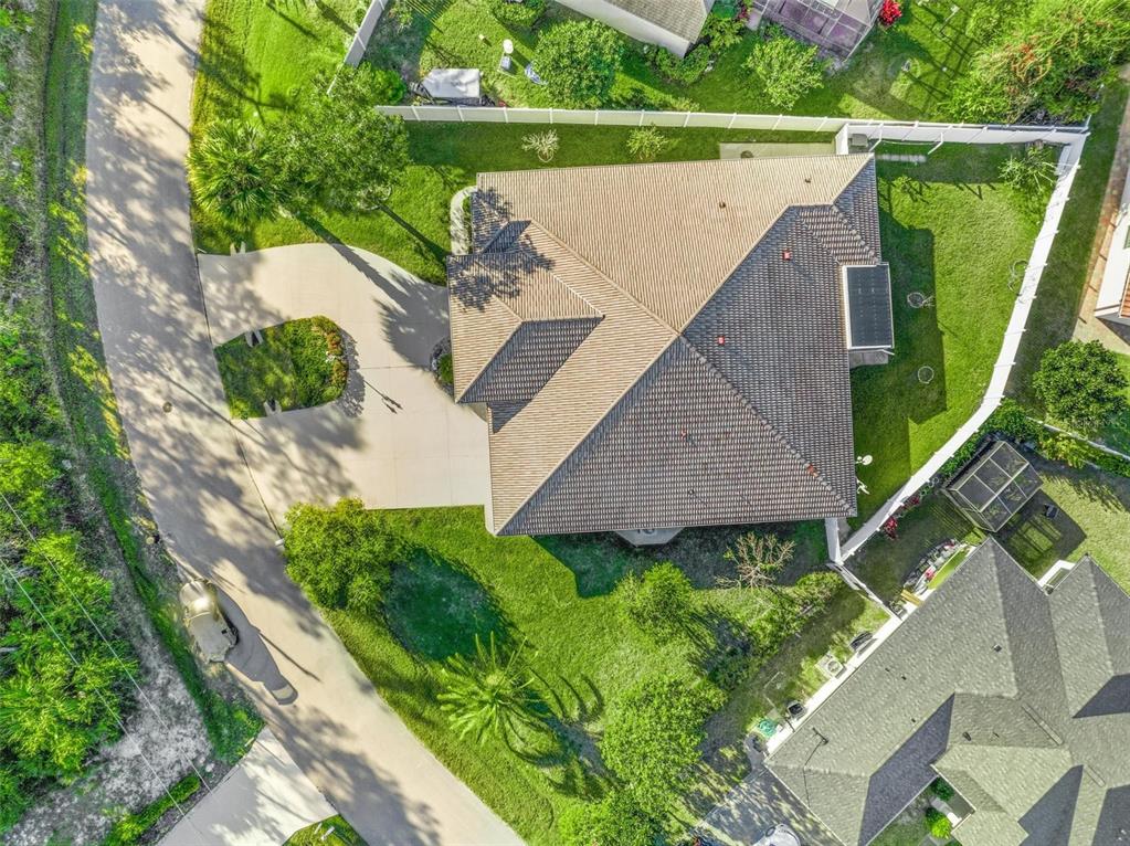 An aerial view shows a house with a multi-faceted roof, driveway, and surrounding yard — 3 FALLS PLACE, PALM COAST, FL