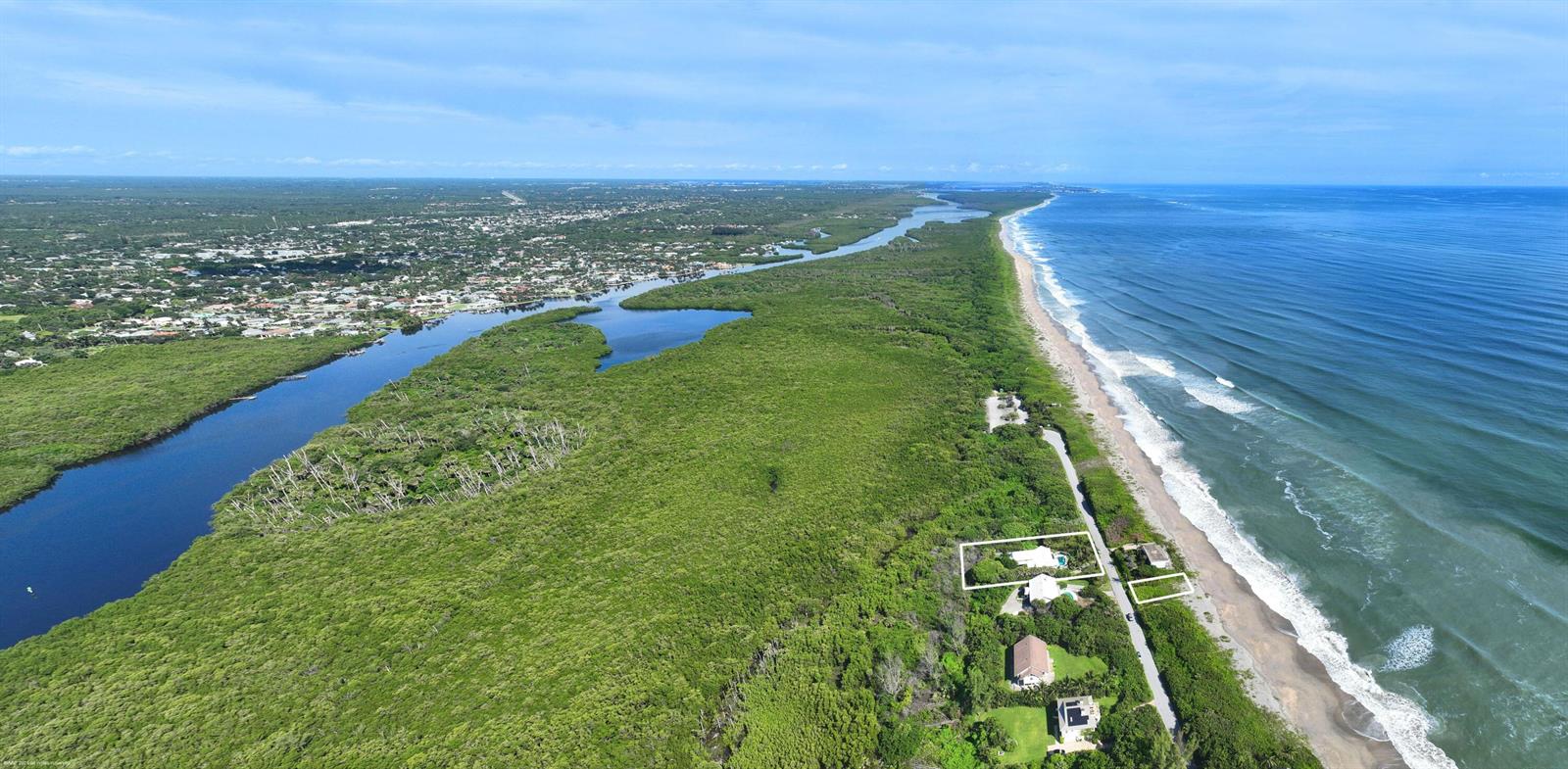 An aerial view shows houses situated between a dense forest, a river, and the ocean — 162 N Beach Road, Jupiter Island FL 33455, JUPITER ISLAND, FL