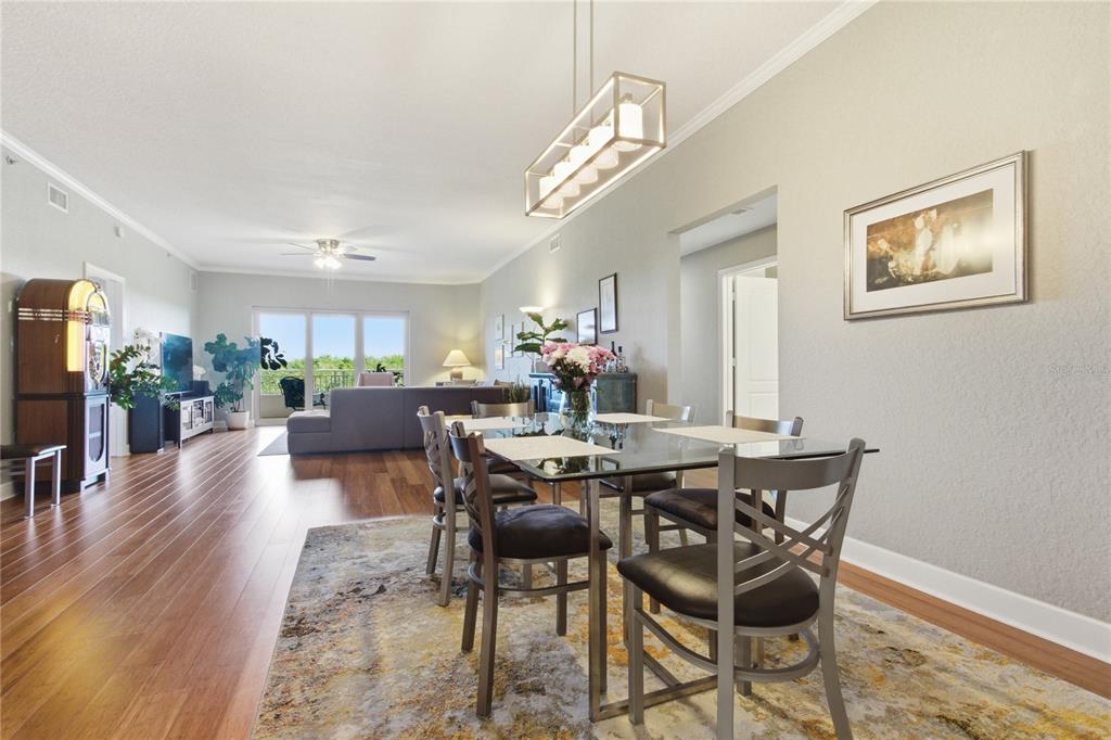A dining area with a glass table and chairs opens into a living room — 12055 GANDY BOULEVARD N UNIT 243, ST PETERSBURG, FL