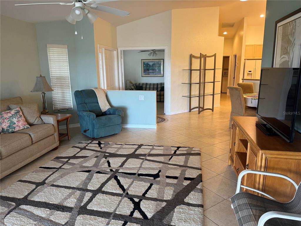 A living room features tile floors, a patterned area rug, a recliner, and a sofa — 4049 FAIRWAY DRIVE, NORTH PORT, FL