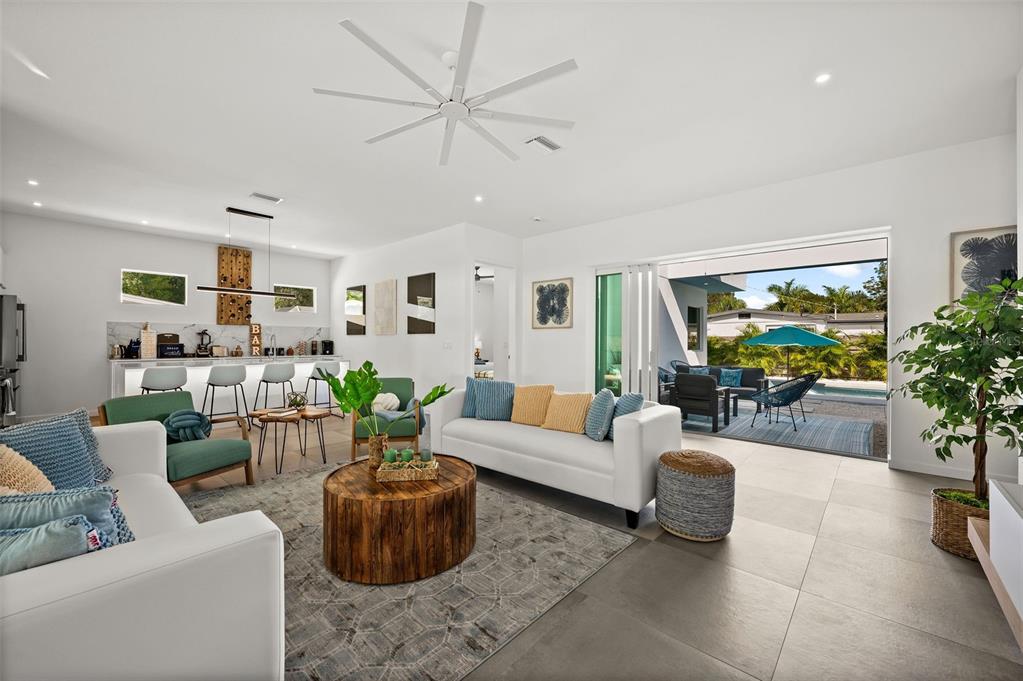 A modern living room with white sofas, a wooden coffee table, and an open-concept kitchen — 2365 WALDEMERE STREET, SARASOTA, FL