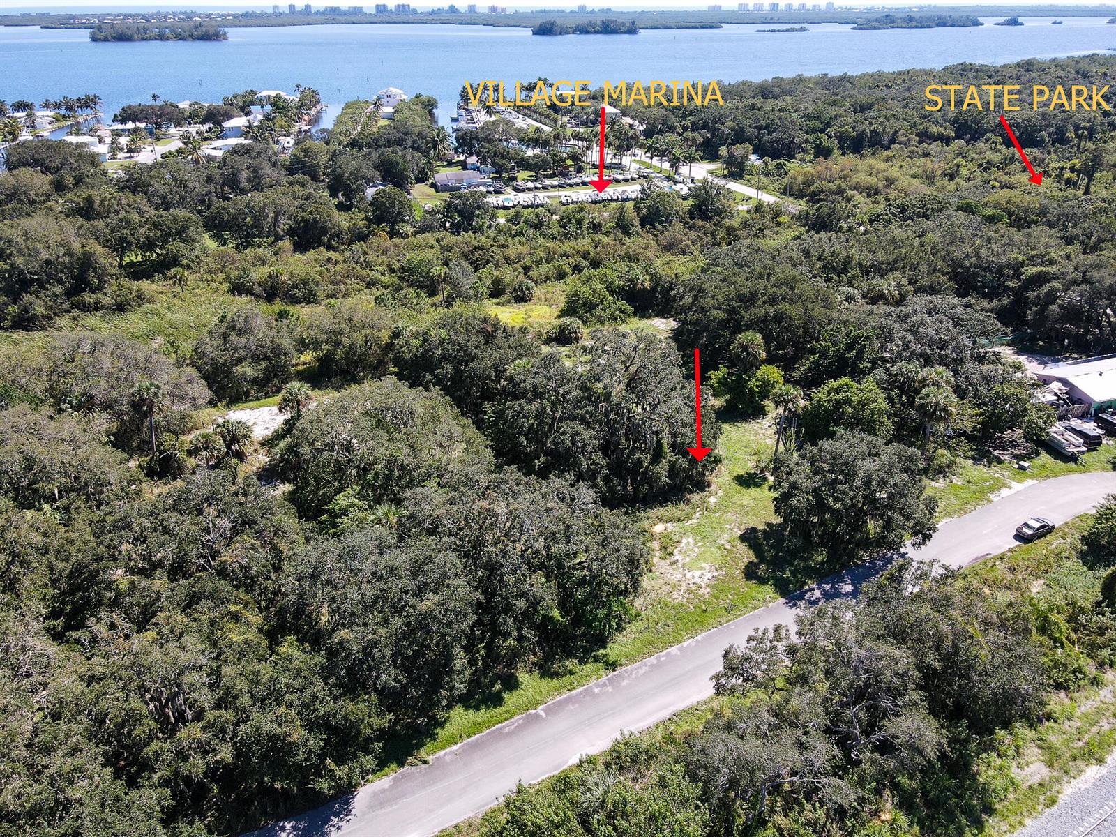 An aerial view shows a wooded lot near a marina and a state park — 4108 Mariner Oaks Way, FL 34946, FL