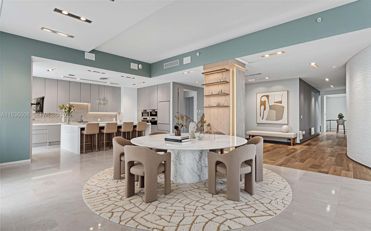 A modern open-concept dining and kitchen area features a marble table and neutral-toned furniture — 900 Brickell Key Blvd # 1002, Miami FL 33131, MIAMI, FL