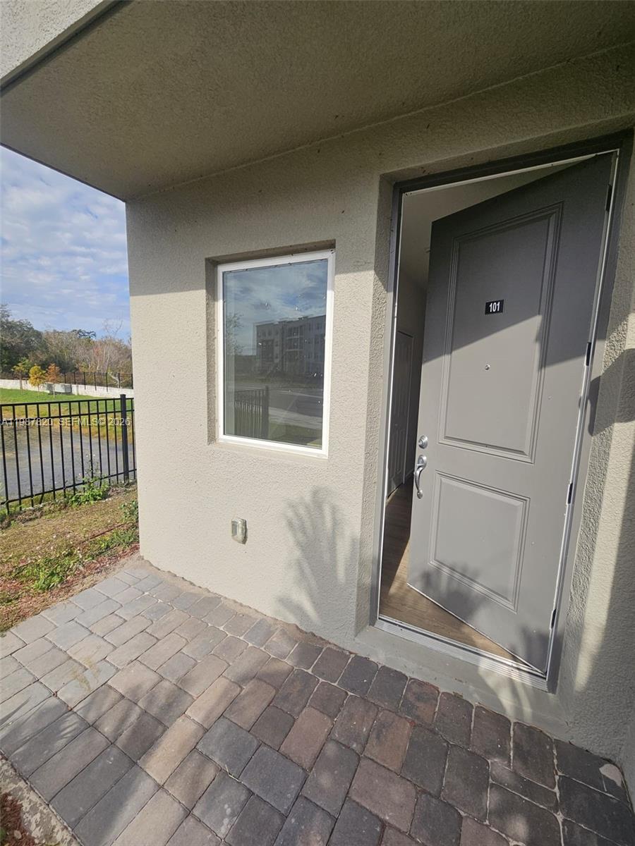 A gray front door labeled 101 opens to a unit with a paved patio area — 1201 Southstation PL # 101, Orlando FL 32809, ORLANDO, FL