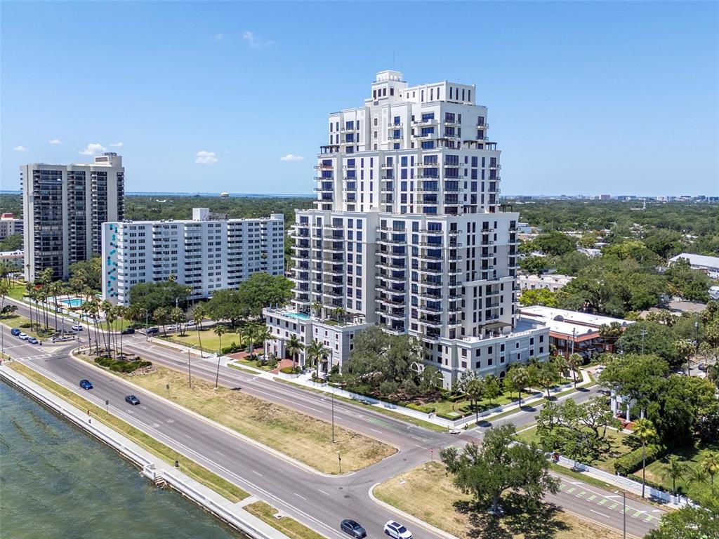 An aerial view shows a tall residential building near a coastal road and water — 2103 BAYSHORE BOULEVARD UNIT 602, TAMPA, FL