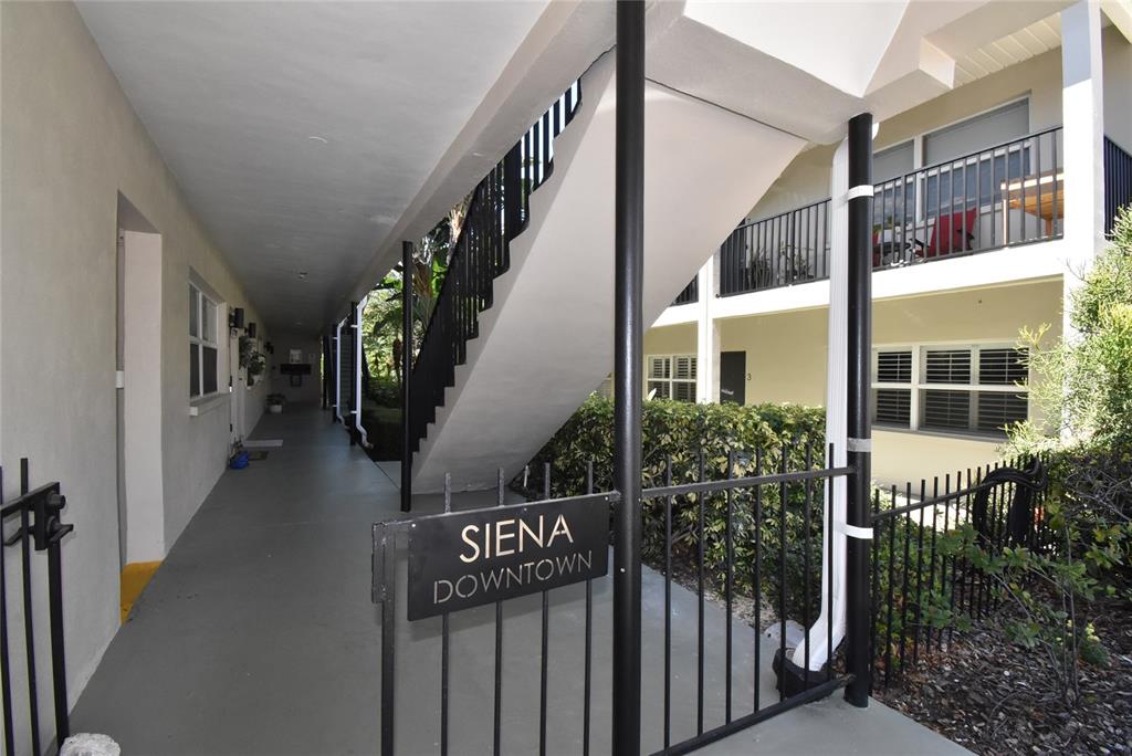 An outdoor walkway leads to a staircase at the Siena Downtown apartment complex — 220 6TH AVENUE N UNIT 11, ST PETERSBURG, FL