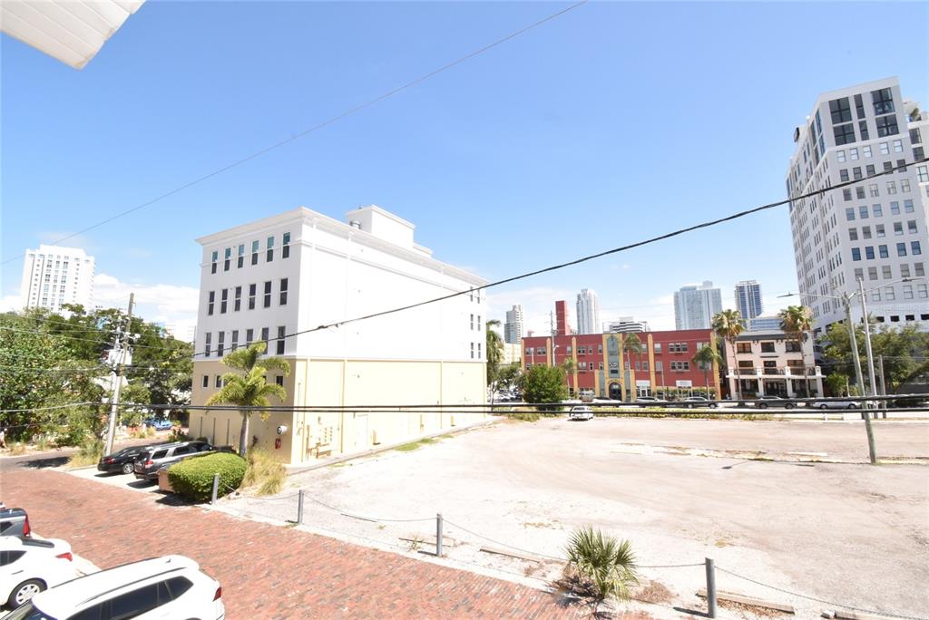 An elevated view shows a vacant dirt lot surrounded by city buildings and parked cars — 220 6TH AVENUE N UNIT 11, ST PETERSBURG, FL