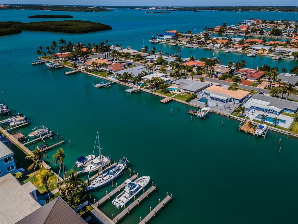 An aerial view of a waterfront residential neighborhood with private docks and docked boats — 12305 3RD STREET E UNIT 2, TREASURE ISLAND, FL