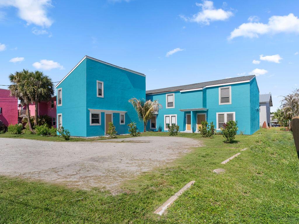 A bright blue two-story apartment building stands behind a gravel parking lot under a sky — 642 & 646 Eldorado Street, Fort Pierce FL 34949, FORT PIERCE, FL