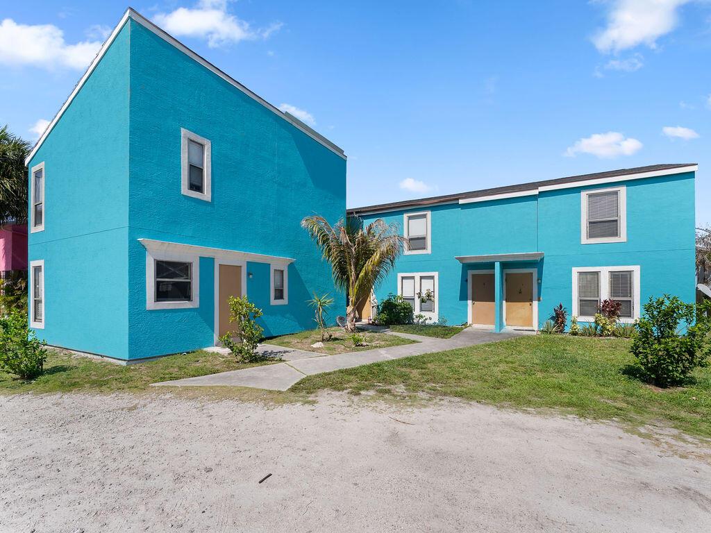 A bright blue two-story apartment building with a concrete walkway and a gravel parking area — 642 & 646 Eldorado Street, Fort Pierce FL 34949, FORT PIERCE, FL