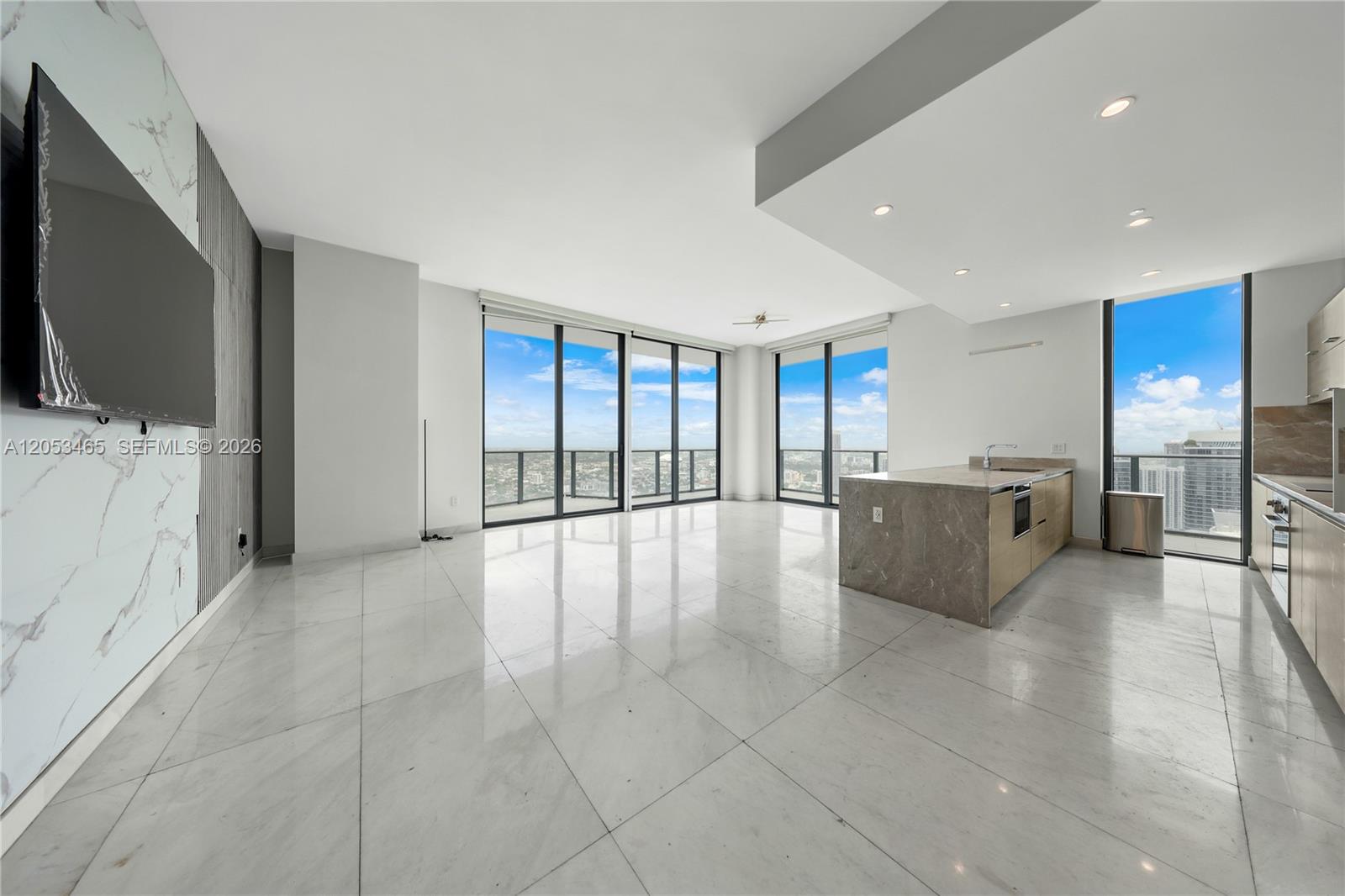 A modern open-concept living area features marble floors, a kitchen island, and floor-to-ceiling windows — 1300 S Miami Ave, Miami FL 33130, MIAMI, FL
