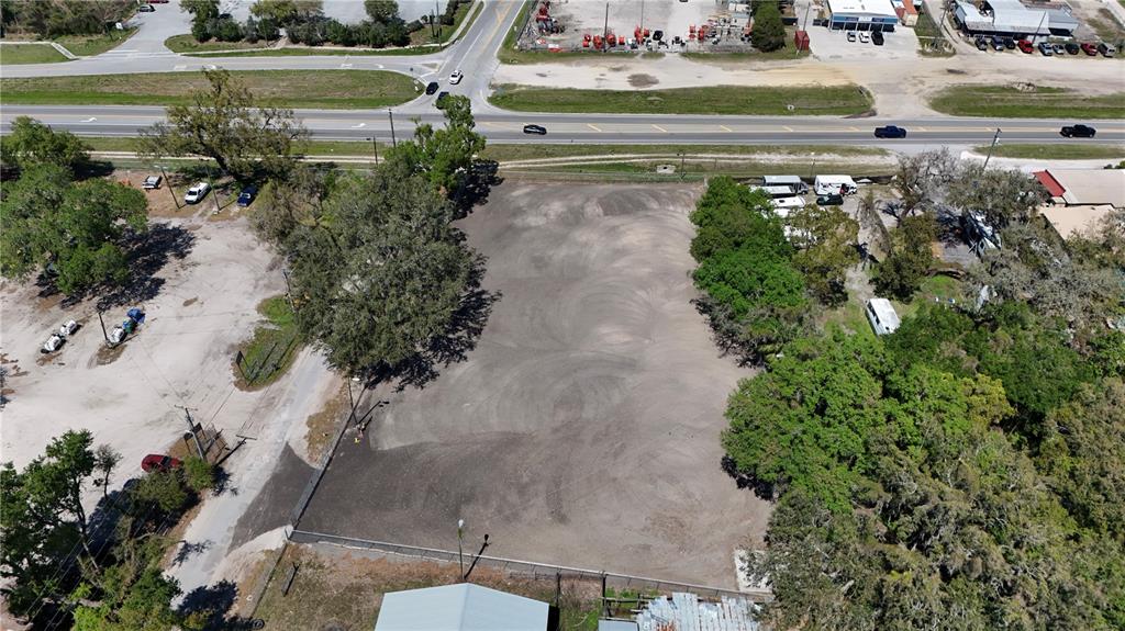 An aerial view shows a cleared, rectangular dirt lot bordered by trees and a road — 11703 N US 301 HIGHWAY, THONOTOSASSA, FL