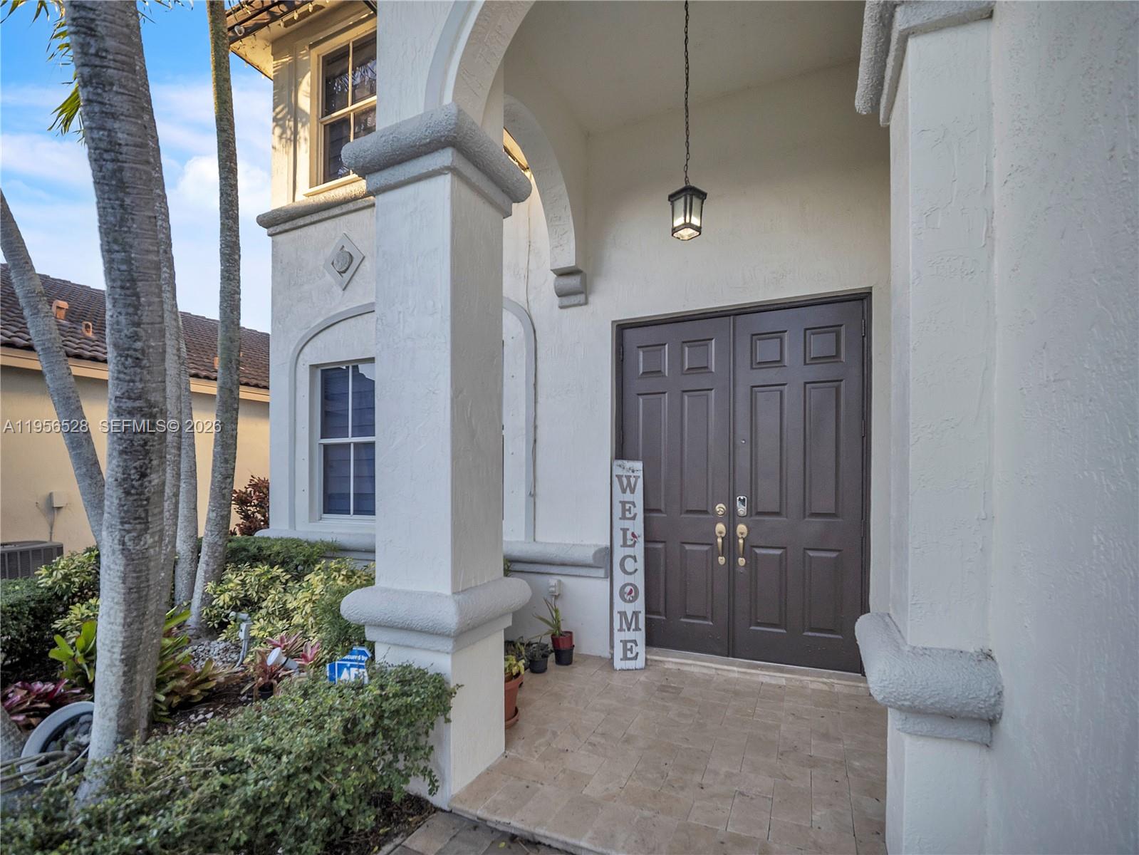 The exterior entrance features a double door, a hanging lantern, and stone-tiled flooring — 15541 SW 21st Ter, Miami FL 33185, MIAMI, FL
