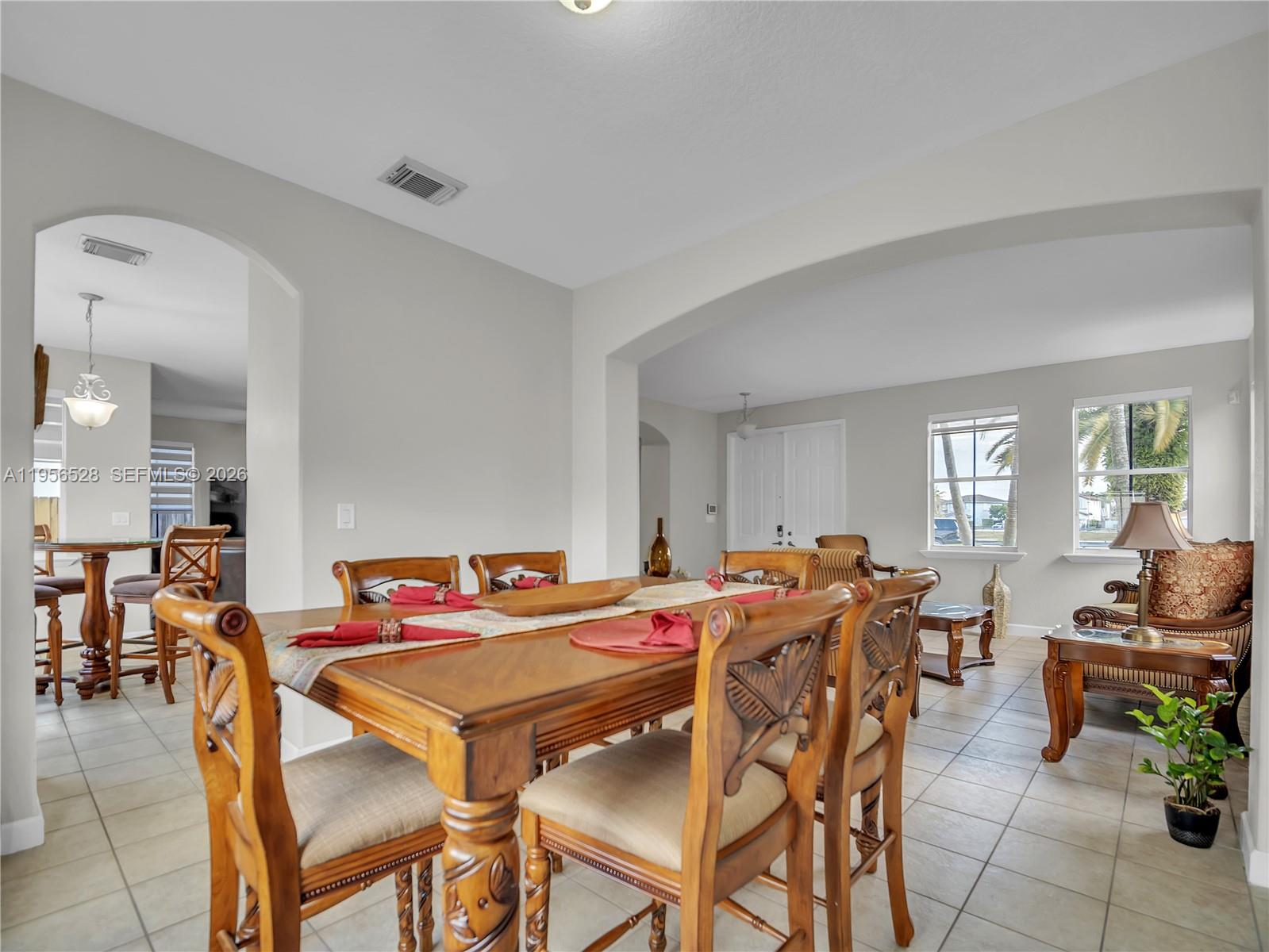 A dining room with a wooden table and chairs opens into a living area — 15541 SW 21st Ter, Miami FL 33185, MIAMI, FL