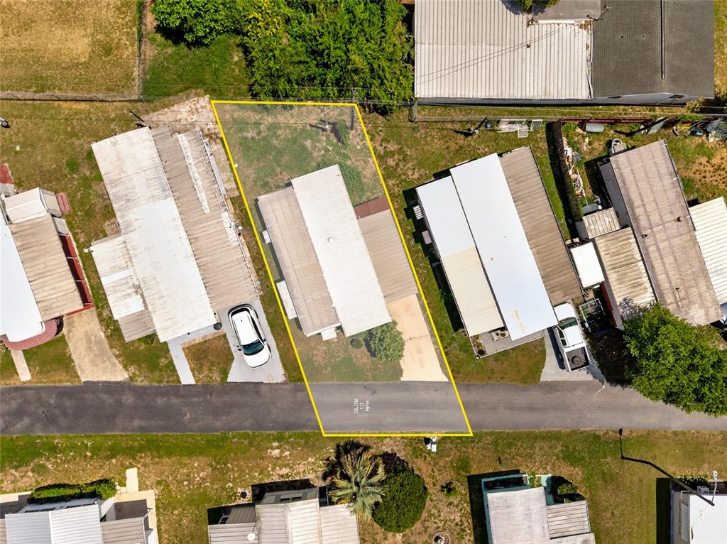 An aerial view shows a mobile home with a driveway and yard outlined in yellow — 37433 RAY DRIVE, ZEPHYRHILLS, FL